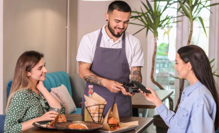 ragazze al ristorante con cameriere