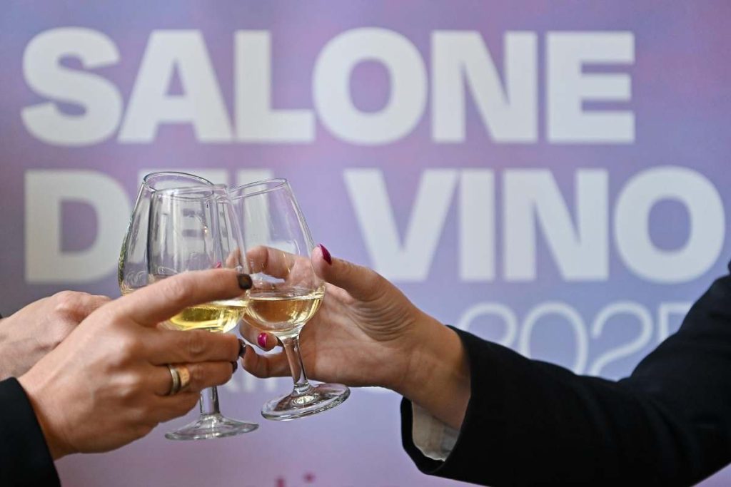 mani che fanno brindisi su sfondo scritta salone del vino