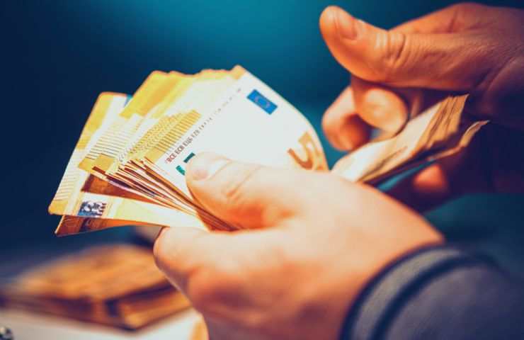 tante banconote da cinquanta euro e mani che le contano